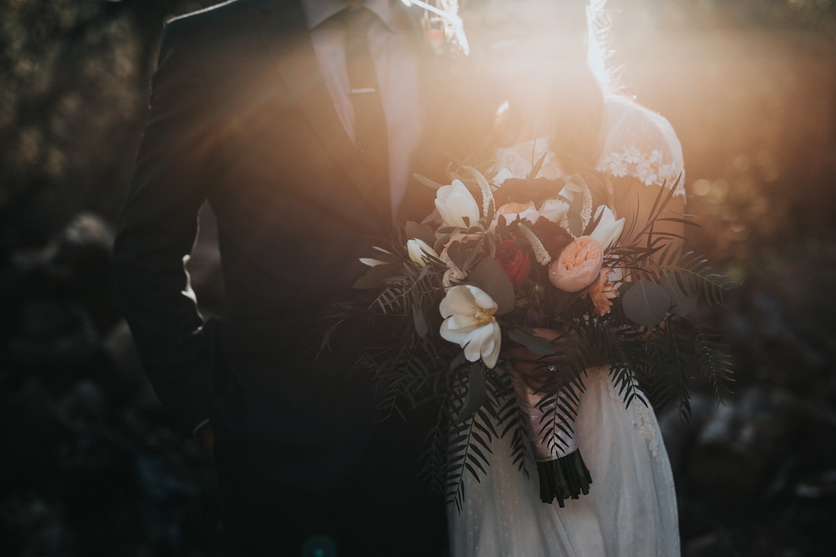 Pasangan pengantin berjalan di taman